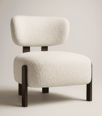 Sella cream upholstered chair with cushioned seat and backrest, supported by dark wooden legs in a minimalist interior setting.