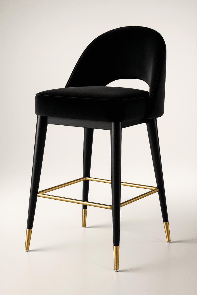Black velvet bar chair with a curved backrest and gold-accented legs, featuring a gold footrest — BOSQUE’s Eclipse model, designed for modern luxury interiors.