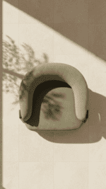 Overhead aerial view of sage green boucle lounge chair on beige tile floor with dappled natural light shadows